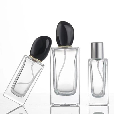 Botella de perfume de vidrio cuadrado de 50 ml de 100 ml de capacidad y tapa de forma irregular